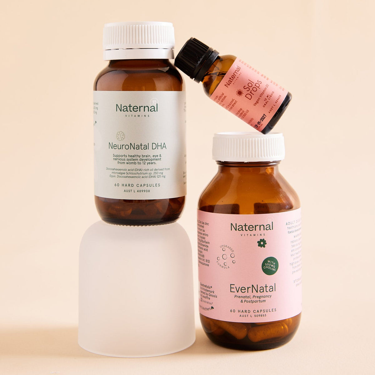 Three bottles of Naternal supplements on a beige background