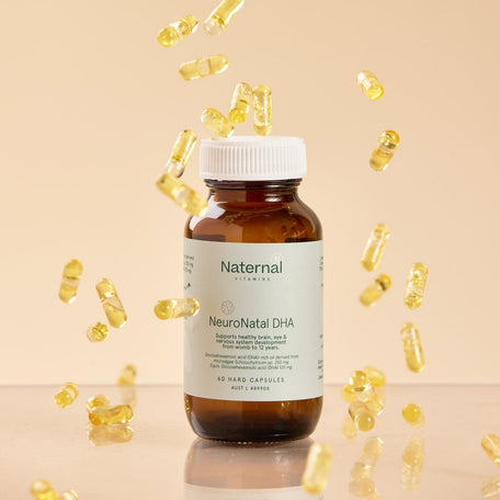 Bottle of Naternal NeuroNatal DHA with scattered capsules on a beige background