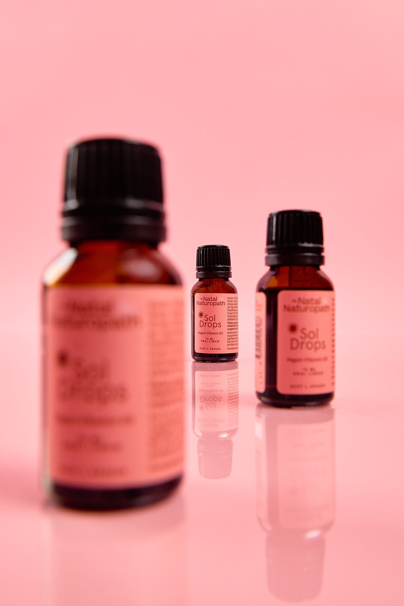 Three bottles of 'Soul Drops' on a pink background