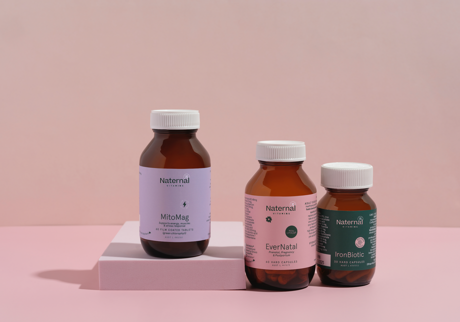 Three bottles of Naternal supplements on a pink platform with a pink background